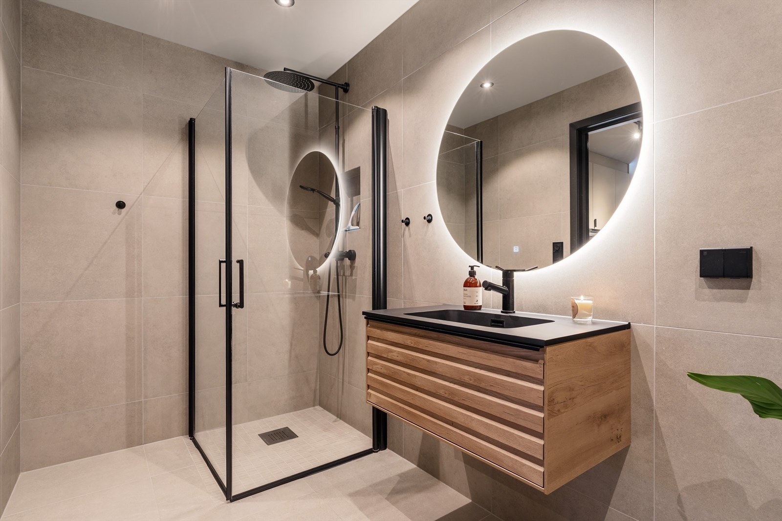 Badet i hybeldelen fremstår som moderne og gjennomført, med dusjhjørne, vegghengt servant og oppgradert baderomsinnredning. Galleribilde