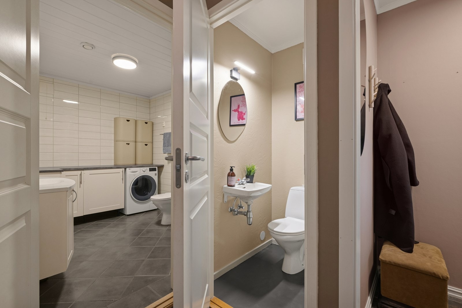 Separat wc-rom med gulvstående toalett og enkel servant på vegg. Galleribilde