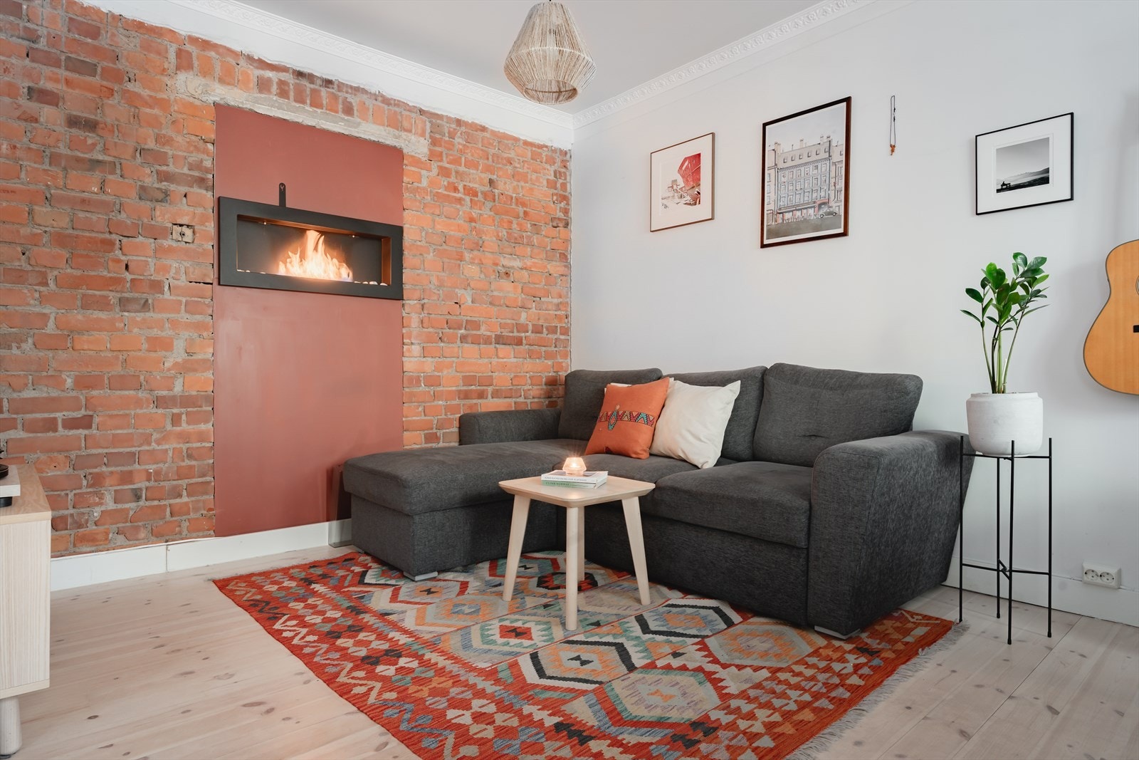 Sjarmerende stue med teglsteinsvegg, stukkatur og biopeis. Galleribilde
