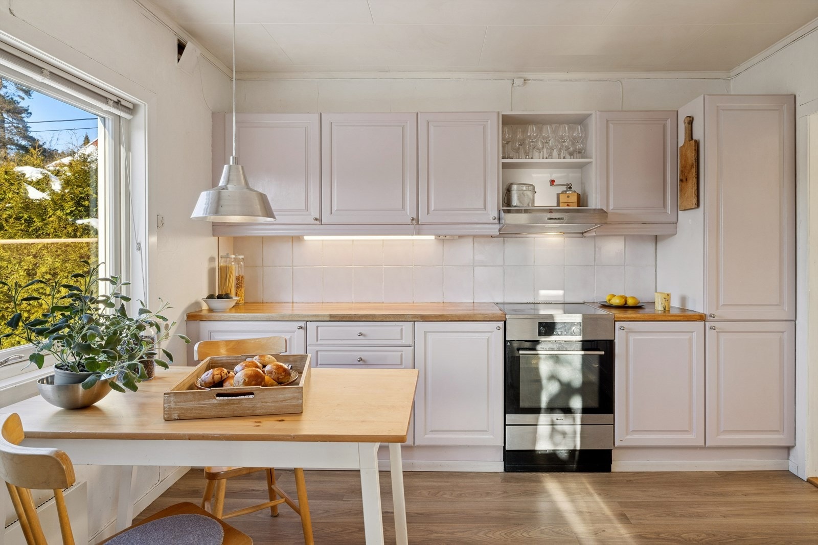 Koselig kjøkken, med kjøkkeninnredning med profilerte fronter. Galleribilde