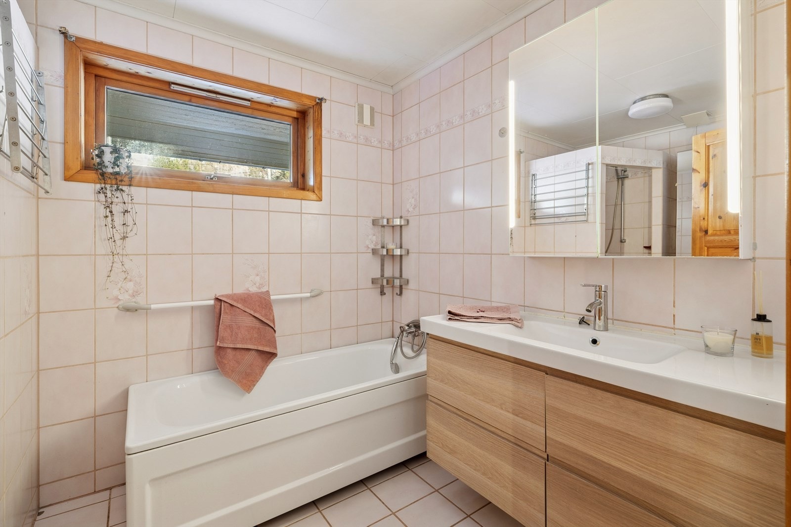 Baderom med flislagt gulv med varmekabler som gir en behagelig varme samt fliser på veggene som skaper et tidløst og rent uttrykk. Galleribilde