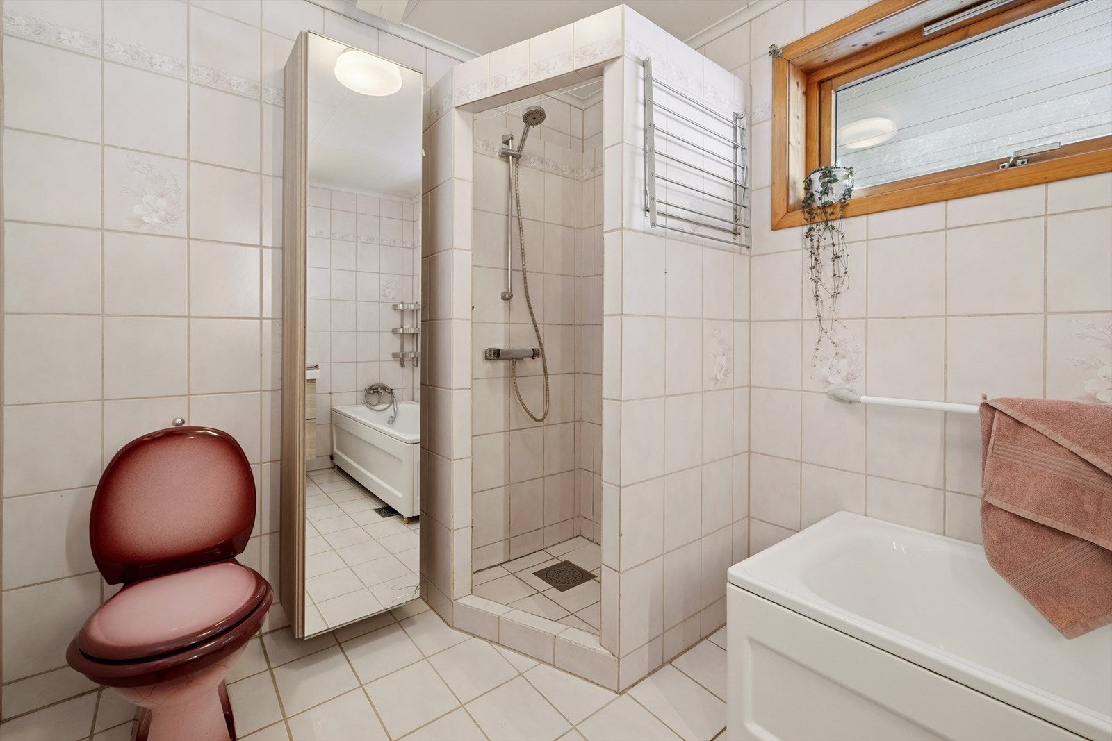 Utstyrt med dusjnisje med sluk i gulvet og et innbydende badekar samt wc. Galleribilde