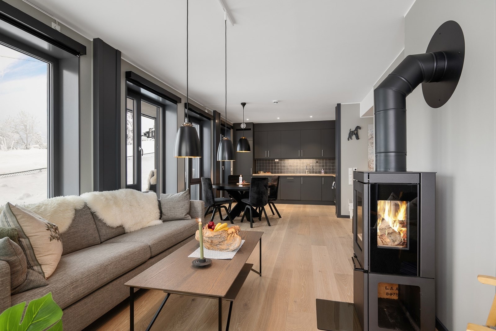 Her er stue og kjøkken i åpen løsning med innsatt peisovn Galleribilde