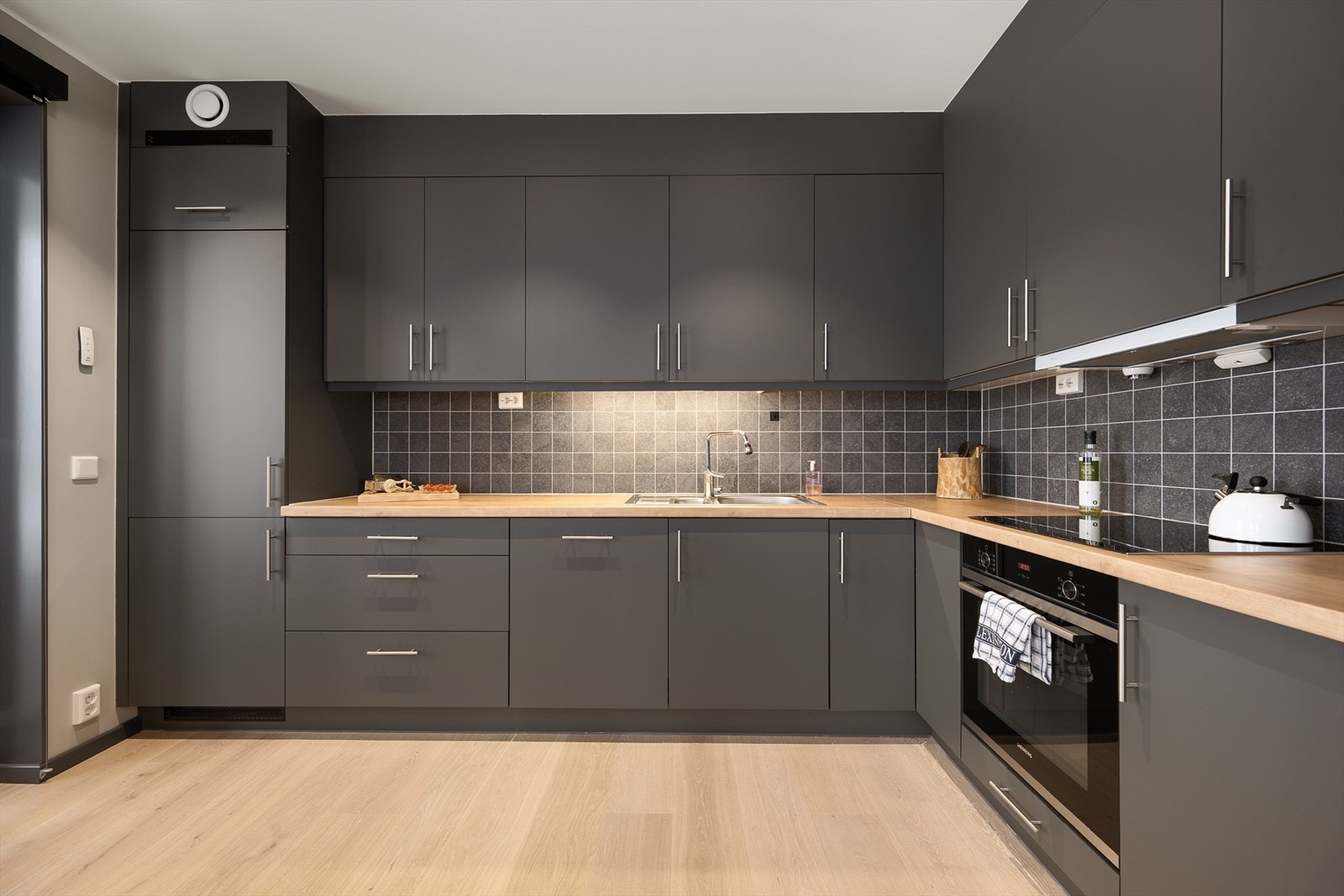 Innredningen har mørke, slette fronter og laminat benkeplate. Galleribilde