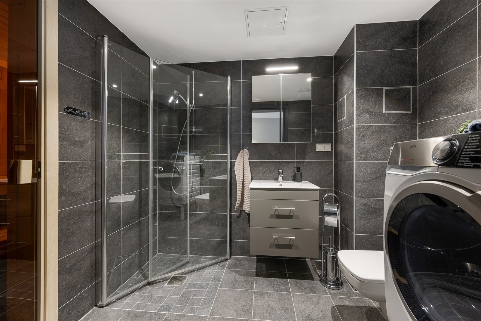 Det ene badet er utstyrt med dusjhjørne, servantinnredning og opplegg for vaskemaskin. Galleribilde