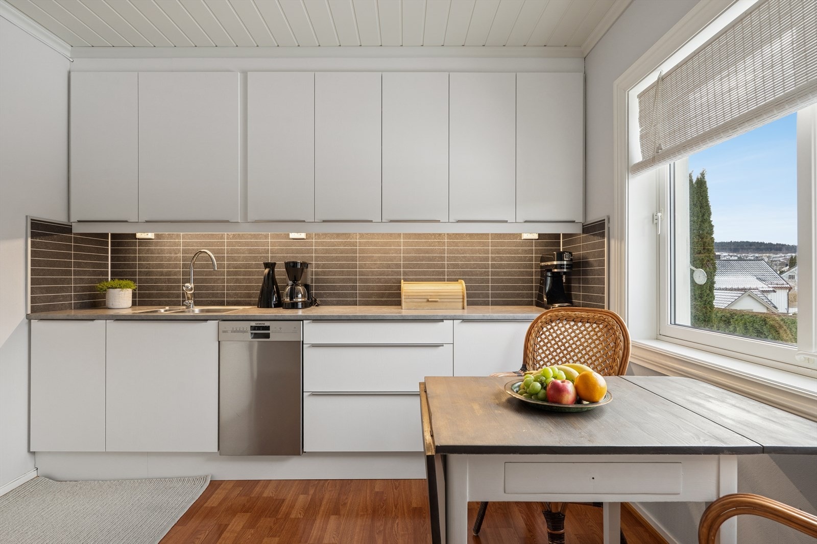 Flisplater på vegg under overskap. Mekanisk avtrekkhette er montert til innredningen og etablert over komfyr. Avtrekk ført til frliluft i yttervegg. Galleribilde