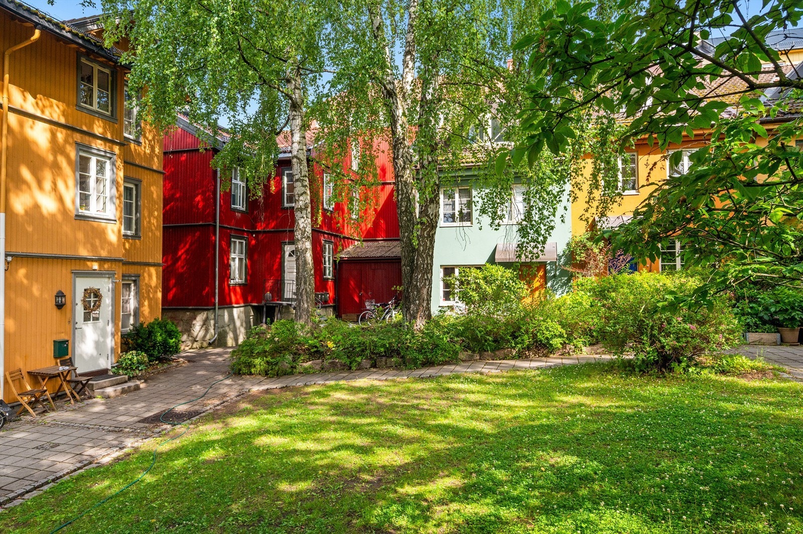 Den frodige bakgården gir en følelse av å bo i en grønn oase midt i byen. Galleribilde