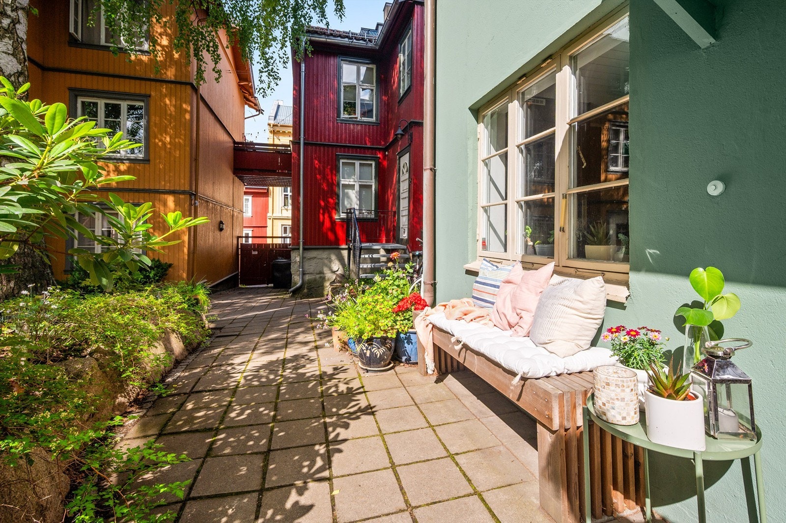 Ved inngangspartiet finner du en trivelig uteplass som ser ut over den sjarmerende trehusbebyggelsen og den grønne bakgården. Galleribilde