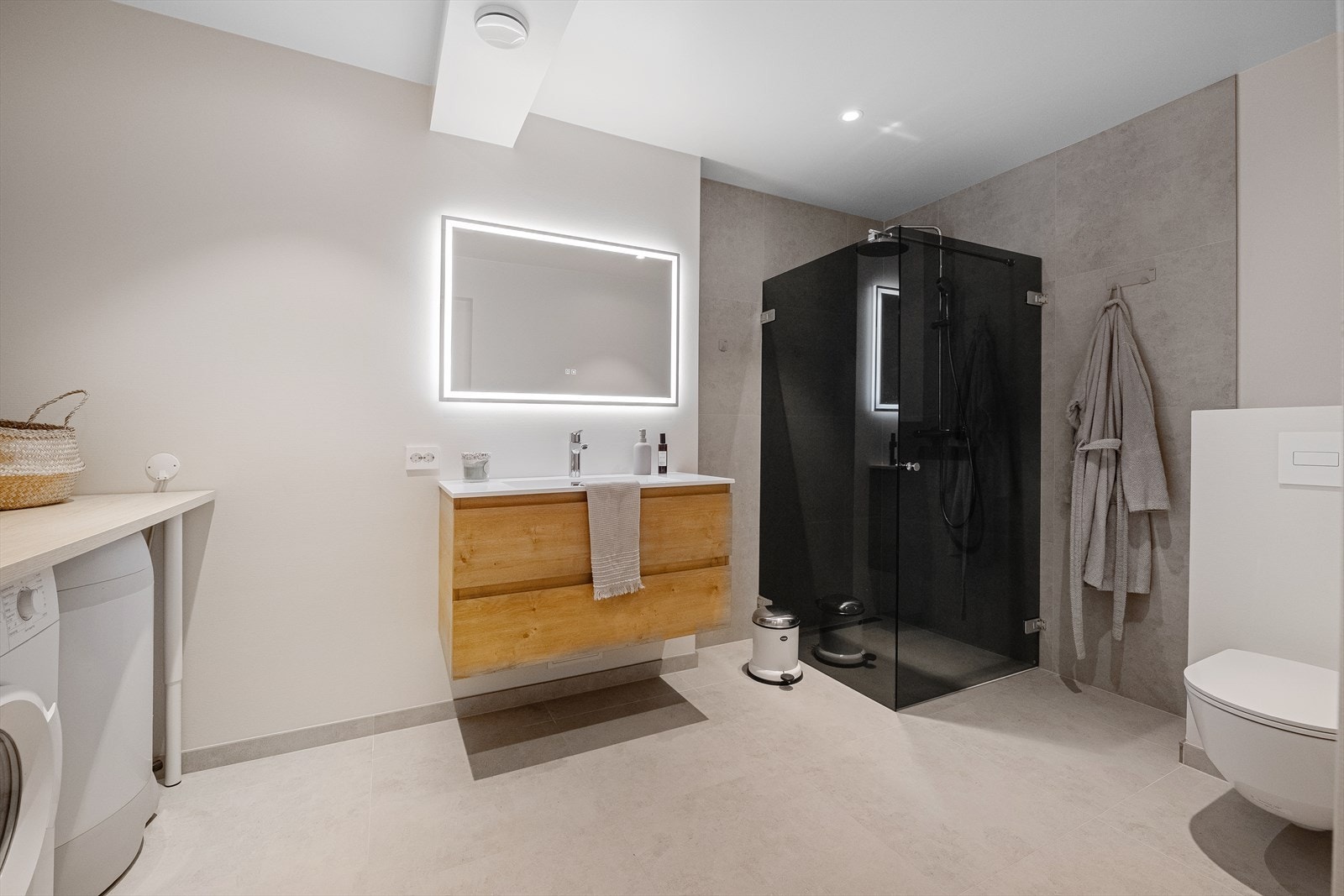 Her har man romslig dusj, vegghengt toalett og praktisk servantløsning med oppbevaring Galleribilde