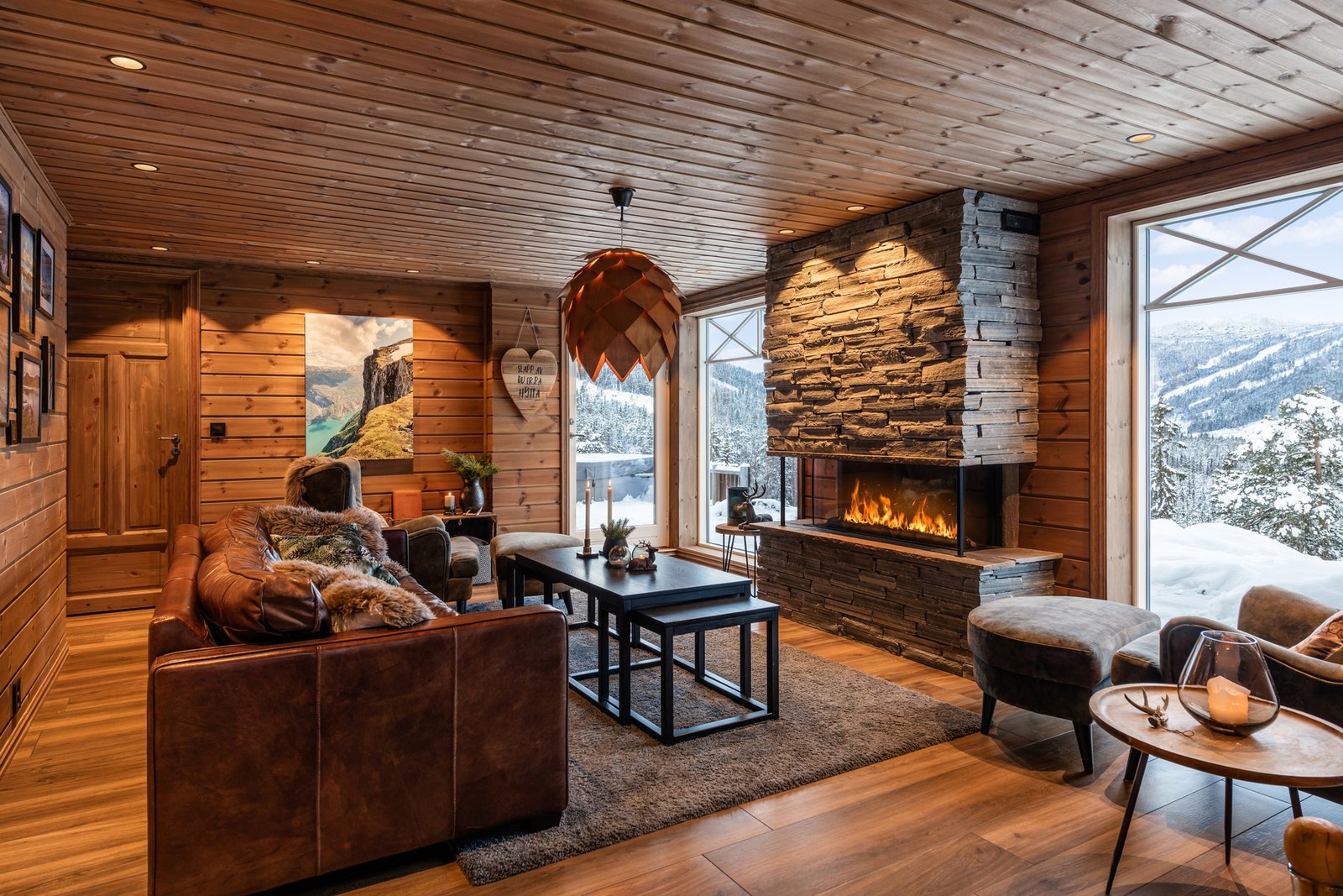 Hytta byr på en lys og innbydende stue med store vindusflater fra gulv til tak med fantastisk utsikt over fjellheimen Galleribilde