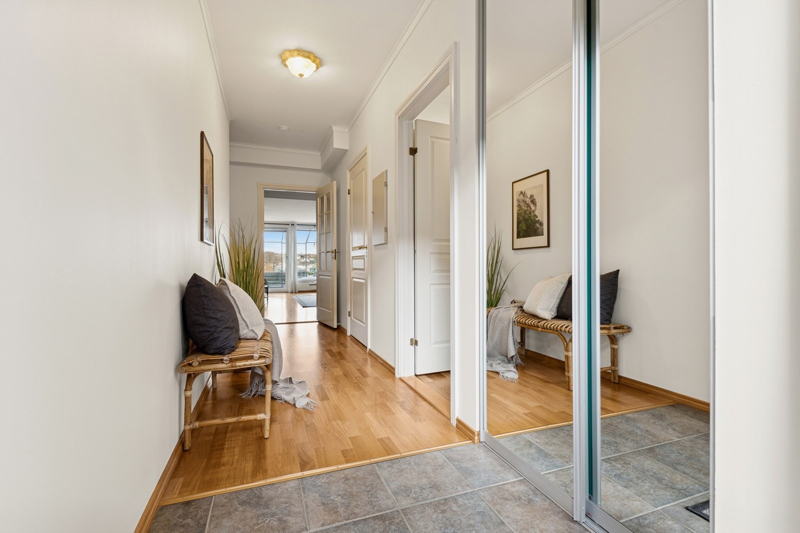 Man ønskes velkommen inn i en lys og romslig gang som er praktisk innredet med flislagt gulv og skyvedørsgarderobe hvor man kan henge fra seg yttertøy og sko. Galleribilde