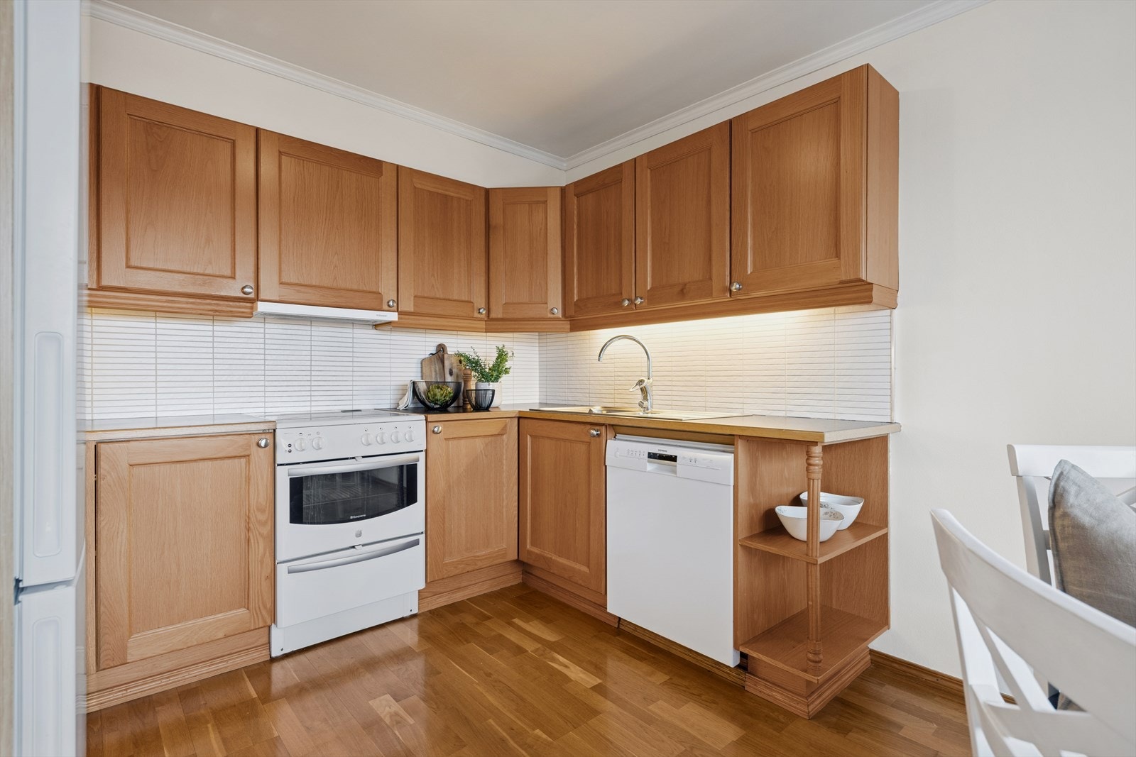 Kjøkkenet er innredet med trefargede, profilerte fronter og lys benkeplate i laminat. Et romslig kjøkken hvor man har godt med skap- og skuffeplass, samt gode arbeidsflater på benk. Galleribilde