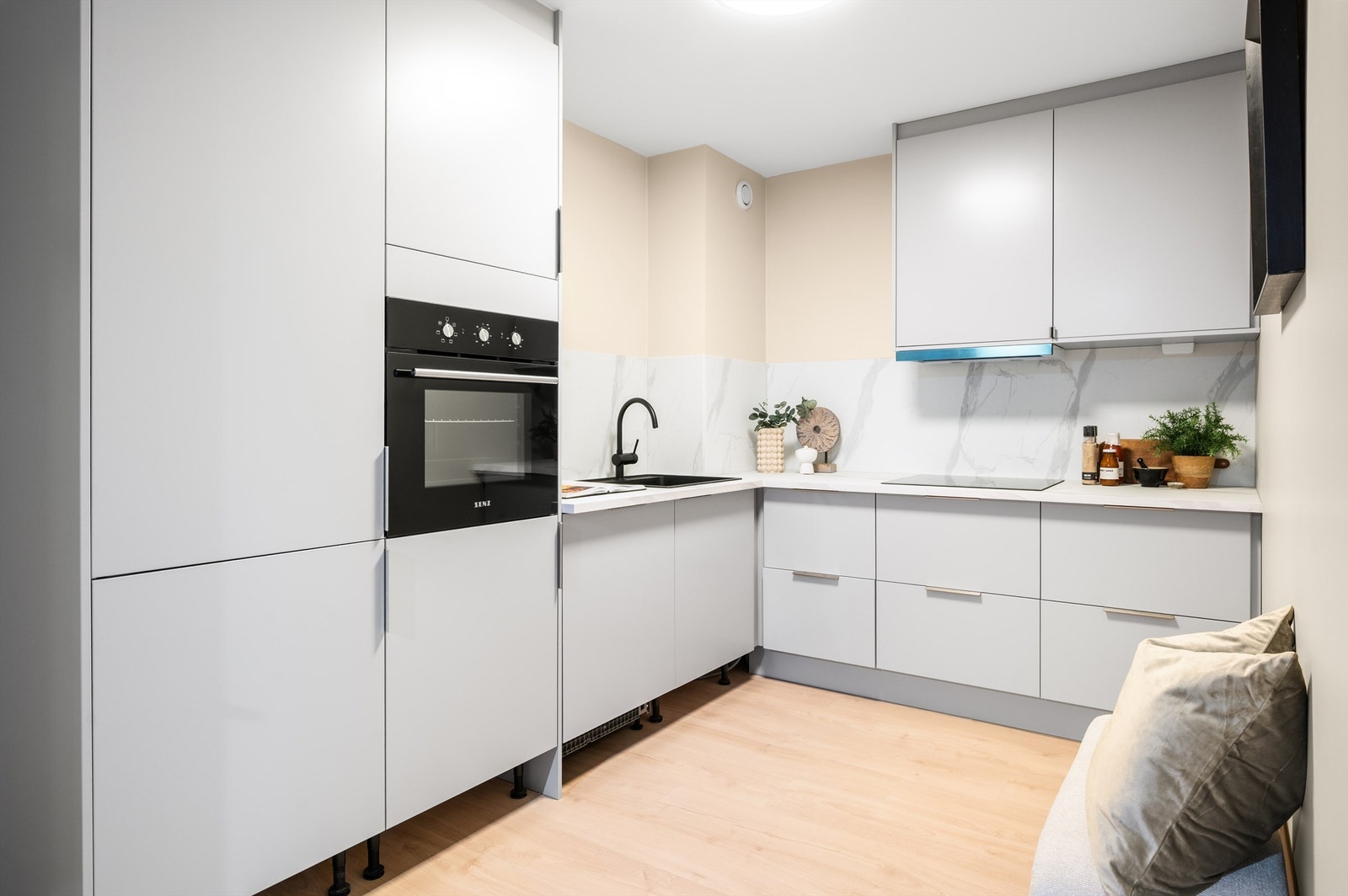 Kjøkkenet er nytt i 2025 med moderne innredning fra Norema med glatte fronter, laminat benkeplate med nedfelt vaskekum, overskap og sprutplater over benkeplaten. List under skap monteres fortløpende. Galleribilde