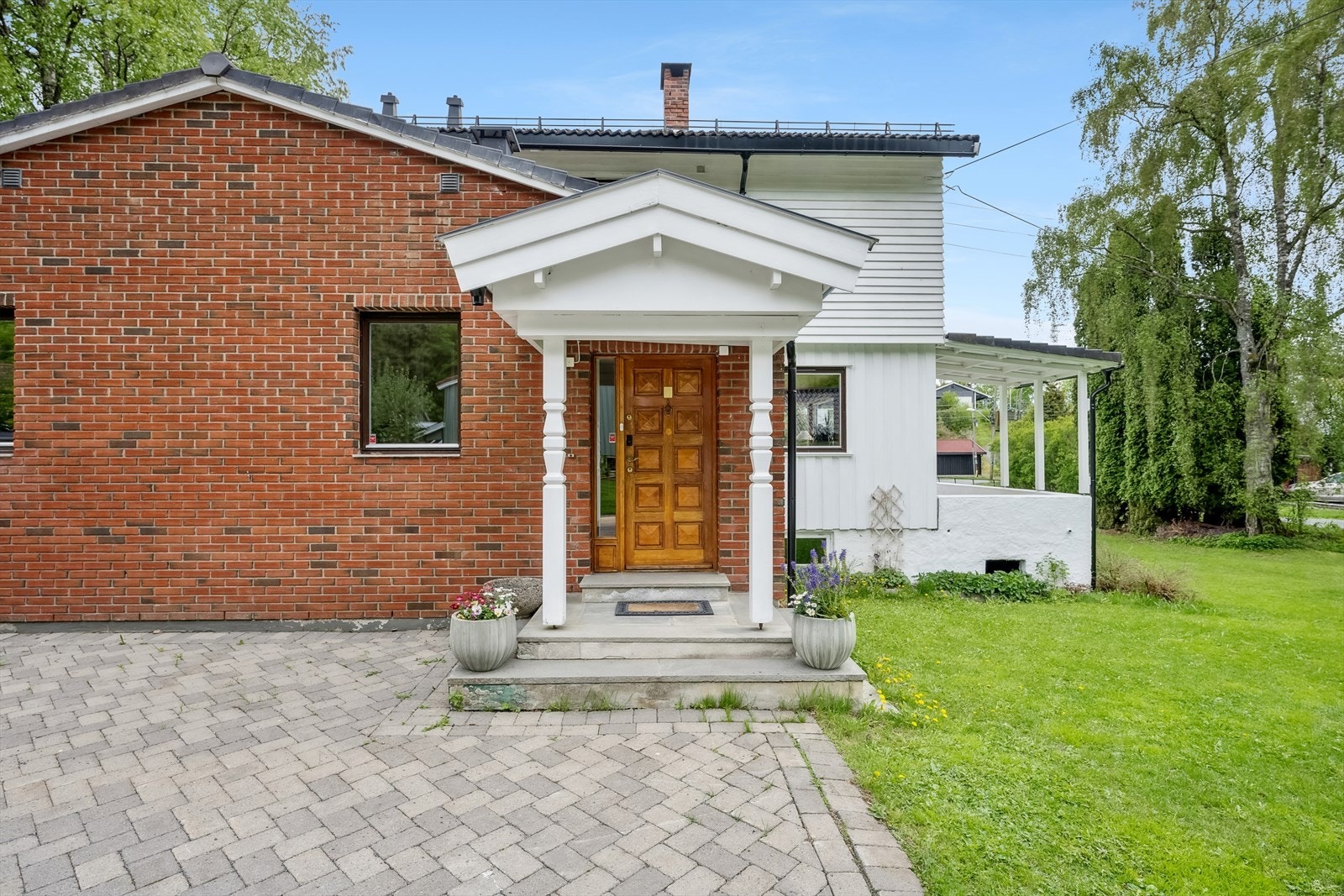 Fra inngangspartiet i 1. etasje - stor stenlagt gårdsplass og dobbel garasje rett utenfor Galleribilde