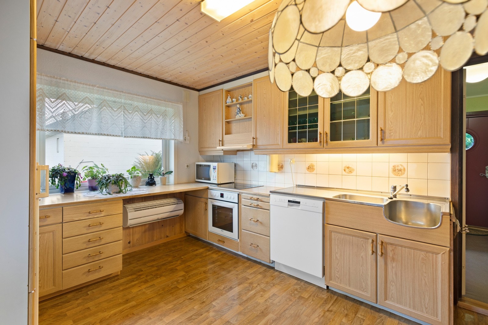 Videre inneholder innredningen laminat benkeplate med flis mot overskap, ventilator, integrert komfyr/platetopp, benkebeslag med oppvaskkum, samt opplegg for oppvaskmaskin. Montert varmepumpe på kjøkkenet. Galleribilde