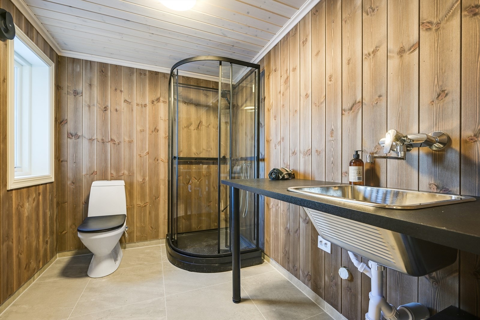 Fra vaskerommet med wc, dusjkabinett, skyllekar og opplegg for vaskemaskin Galleribilde