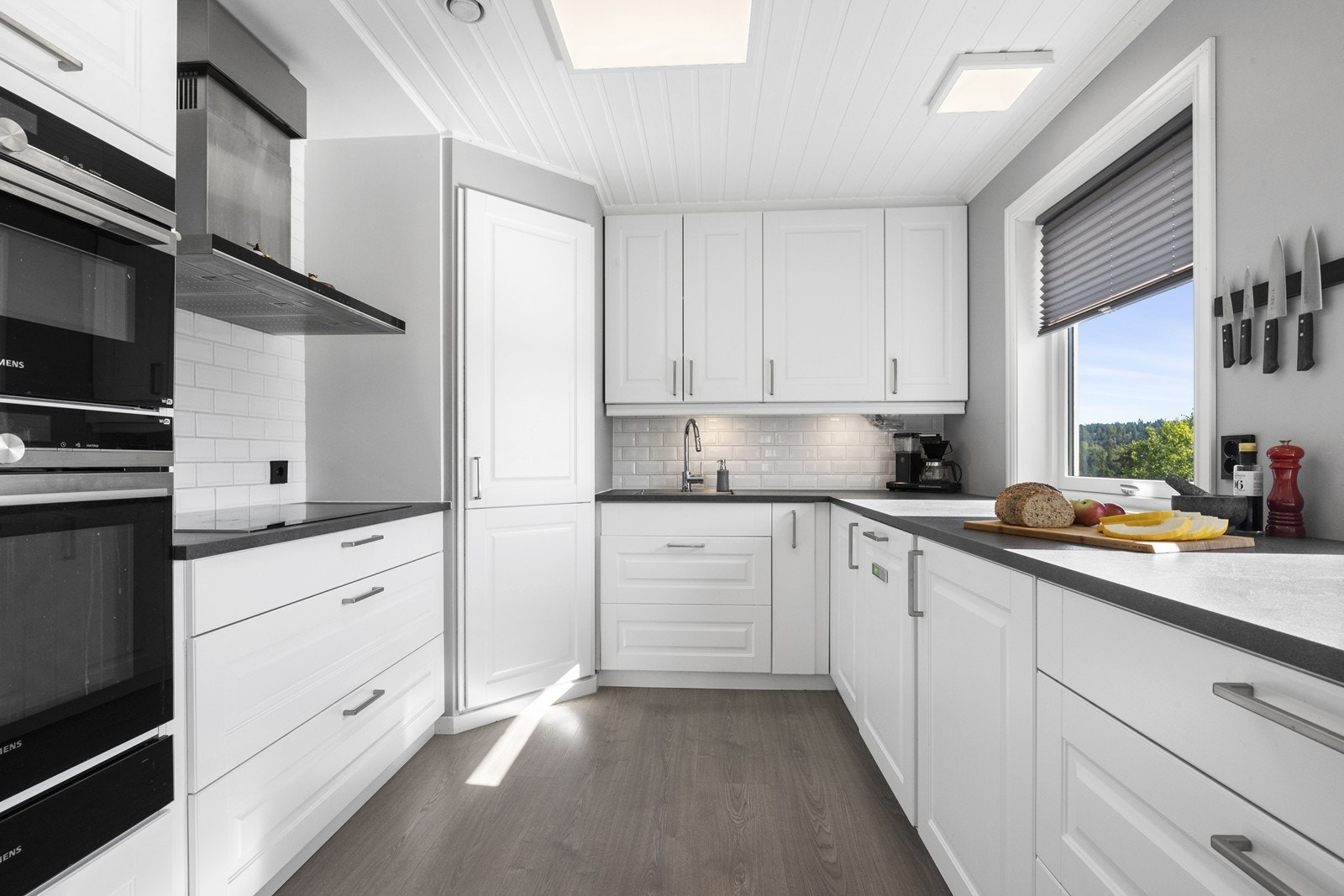 Integrerte hvitevarer som stekeovn, induksjonstopp, mikrobølgeovn, oppvaskmaskin, kjølehjørne og fryseskuff Galleribilde