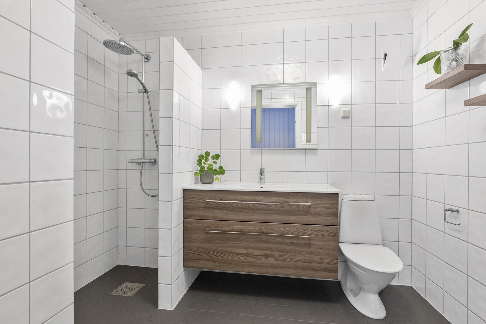 Bad/wc fra byggeår med malte fliser på gulv med gulvvarme, fliser på vegg og malt panel. Nyere innredning med servant Galleribilde