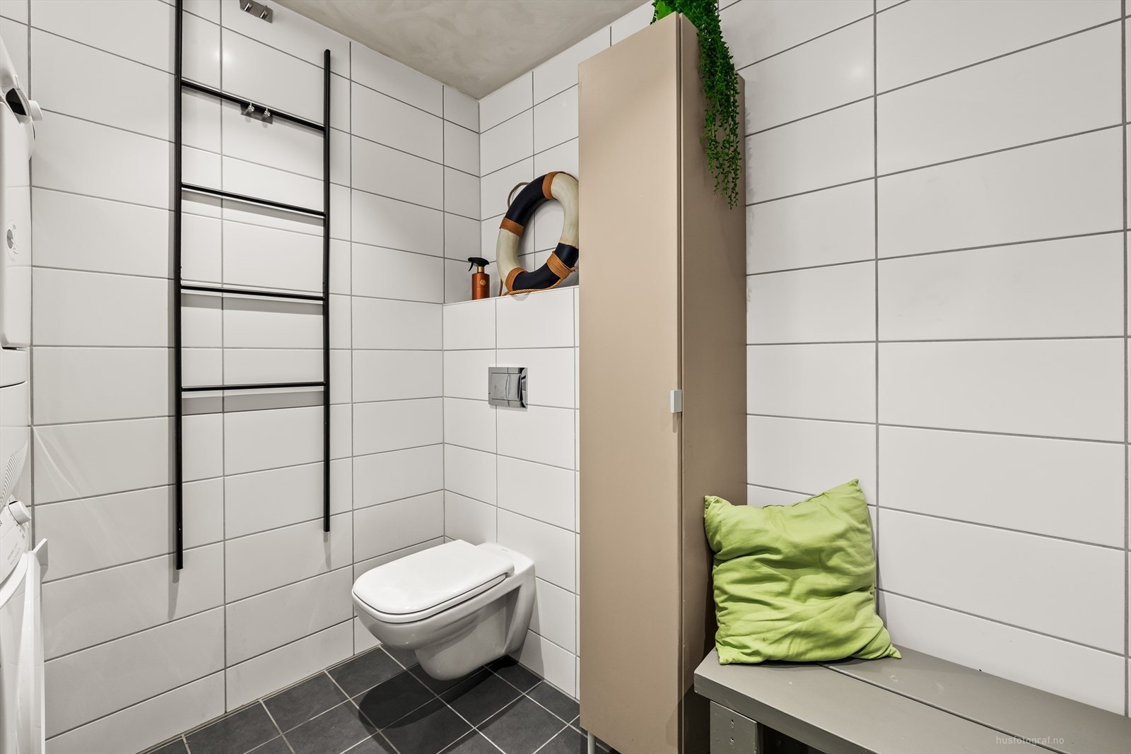 Innredning med to toppmonterte servanter, veggmontert toalett, dusjhjørne med glassvegger og opplegg for vaskemaskin. Galleribilde