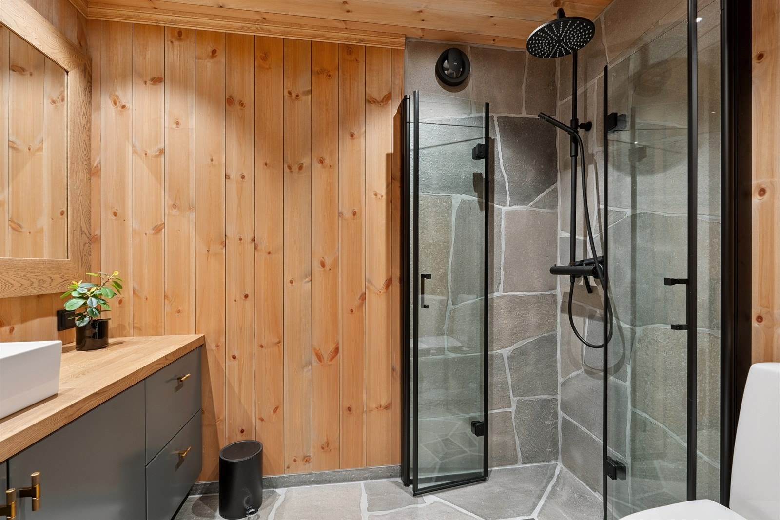 Bad nr. 2 i hytta har gjennomført design og lik utforming som det første badet med skifergulv, varmekabler, servantskap, toalett og dusjhjørne med glassvegger. Galleribilde