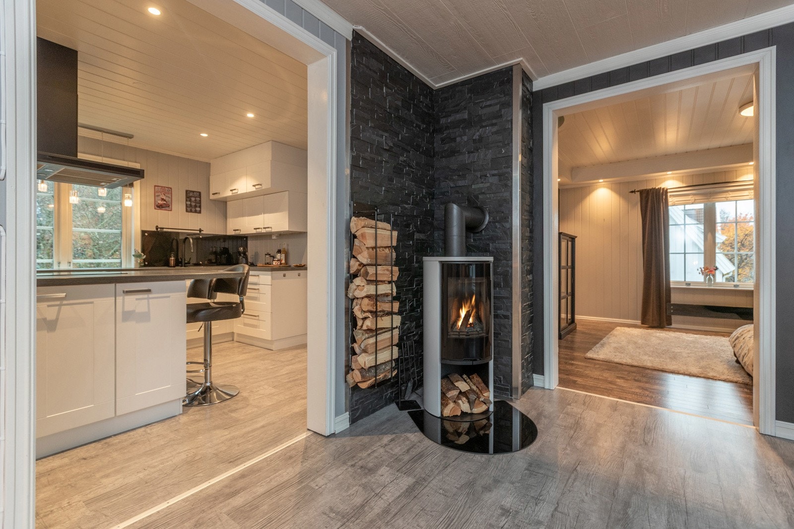 Det er stor åpning mellom det delikate kjøkkenet og dagligstuen med vedovn. Galleribilde