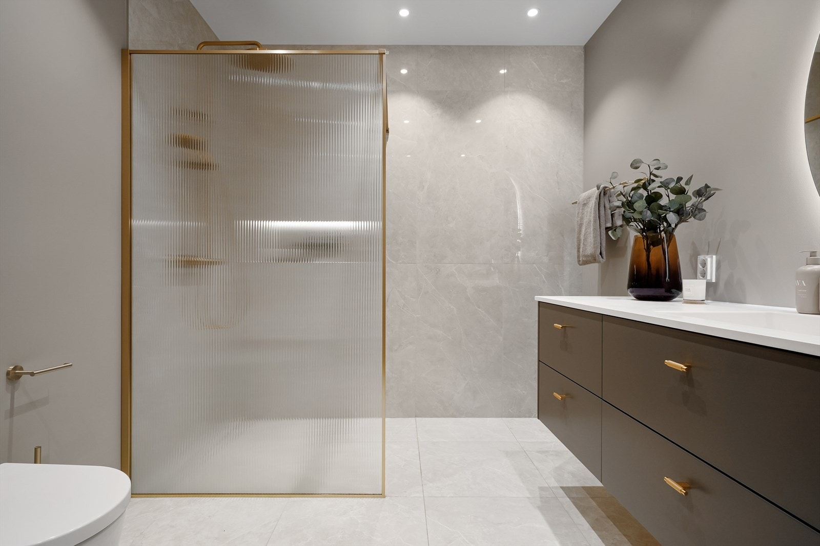 Utstyrt med dobbel servant med rikelig oppbevaring i skuffer, toalett og dusj med glassvegg. Galleribilde