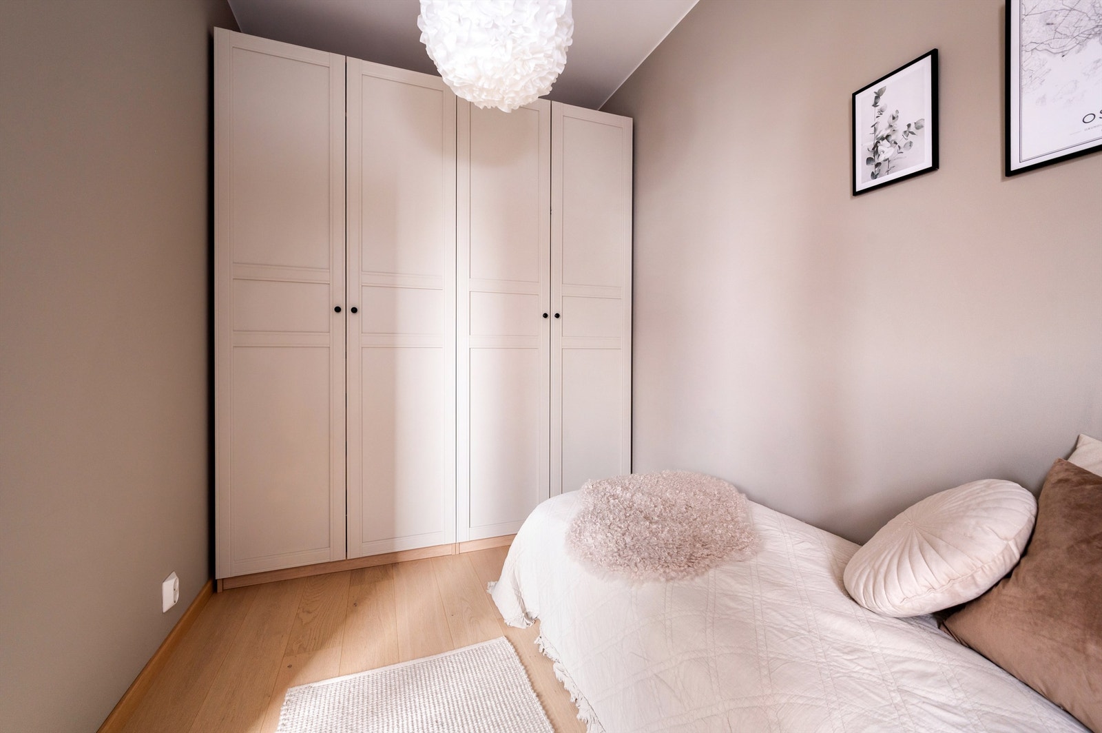 Malte vegger og lekker, enstavs eikeparkett på gulvet samt masser av lysinnslipp fra stort vindu Galleribilde