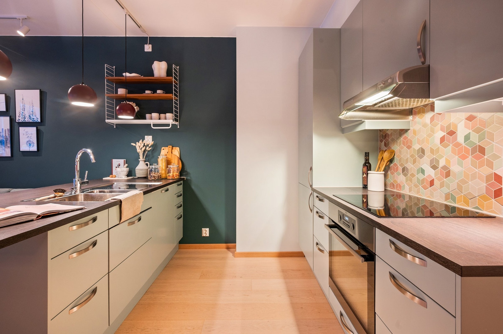 Integrerte hvitevarer som kjøleskap med frysedel, stekeovn, induksjonskoketopp med ventilator over og oppvaskmaskin Galleribilde