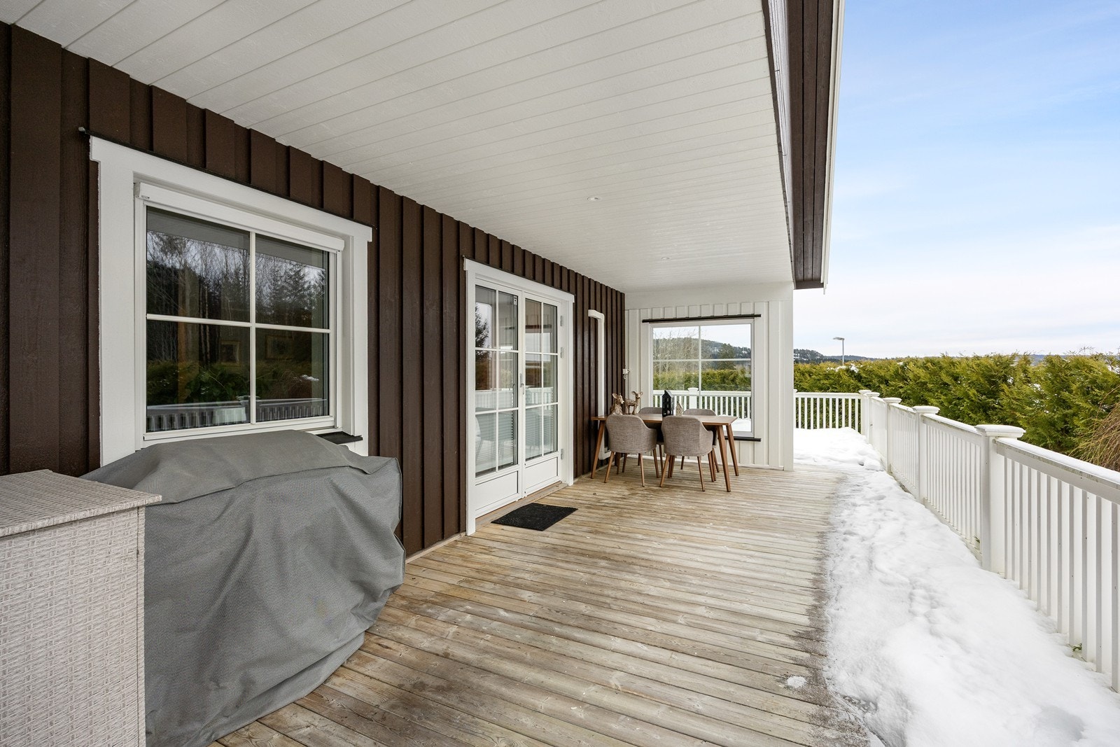 Terrassen har dekke i tre og rekkverk i nærmeste vedlikeholdsfri plast, og det er utestikk på husveggen og downlights i overbygget. Galleribilde