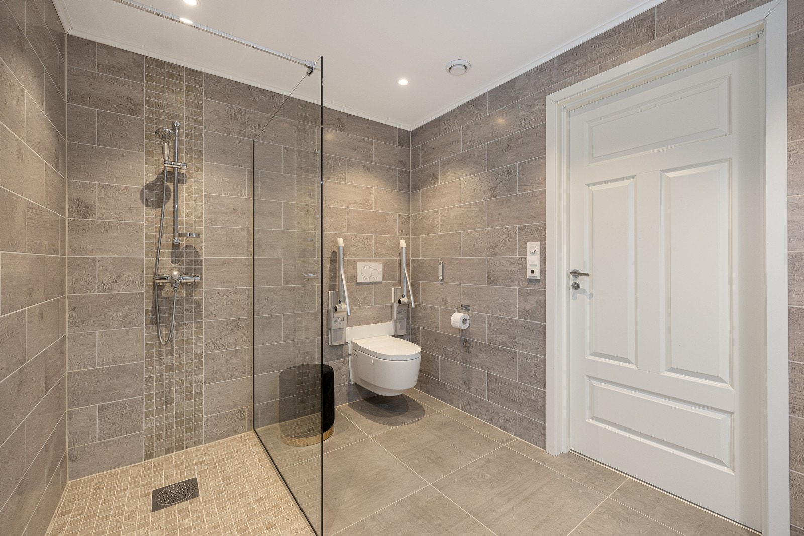 Videre har badet et vegghengt toalett og et dusjhjørne. Galleribilde