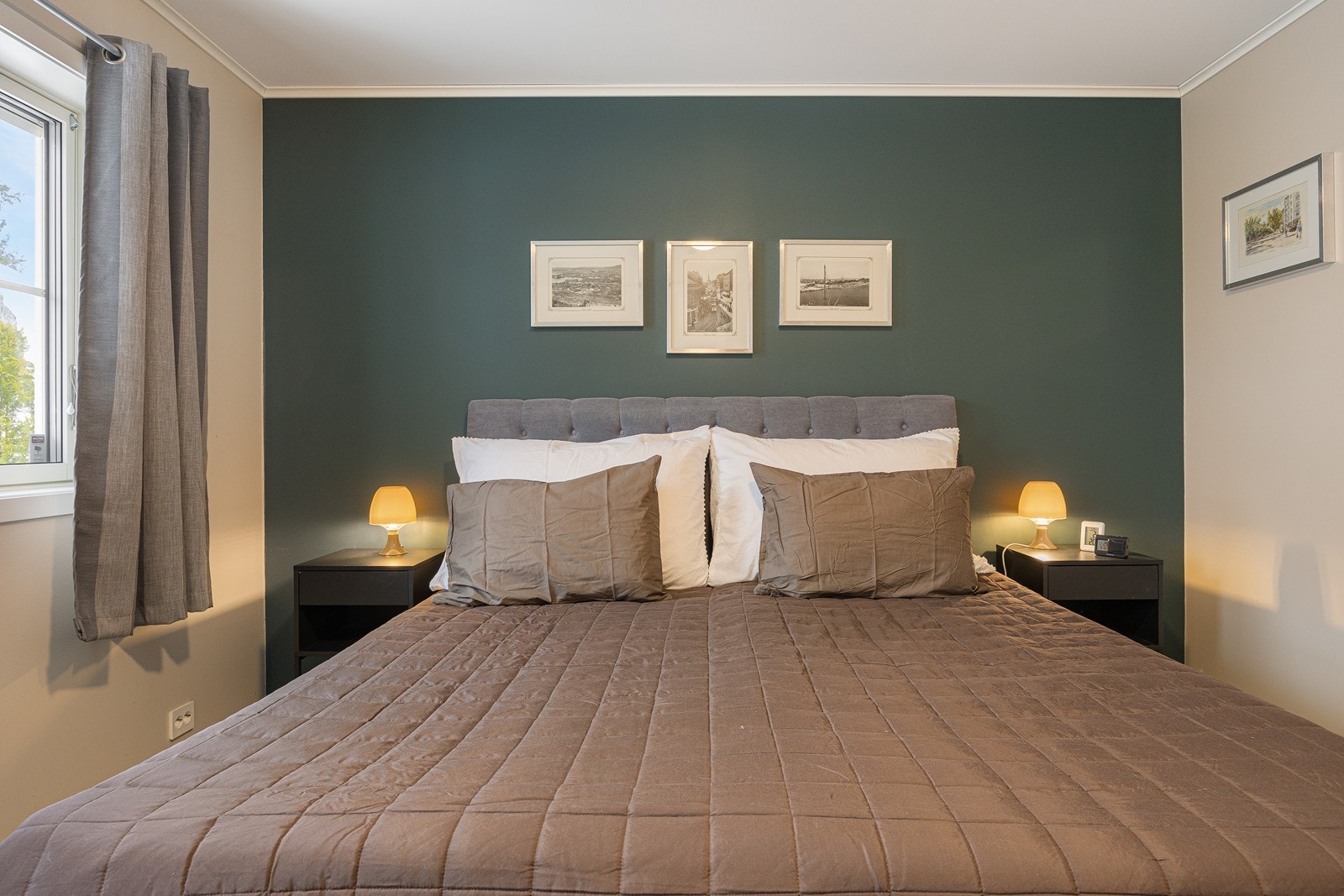 Det er to gode soverom i eneboligen, og begge er holdt i en stilren kombinasjon med beigemalte overflater mot lyse laminatgulv. Galleribilde