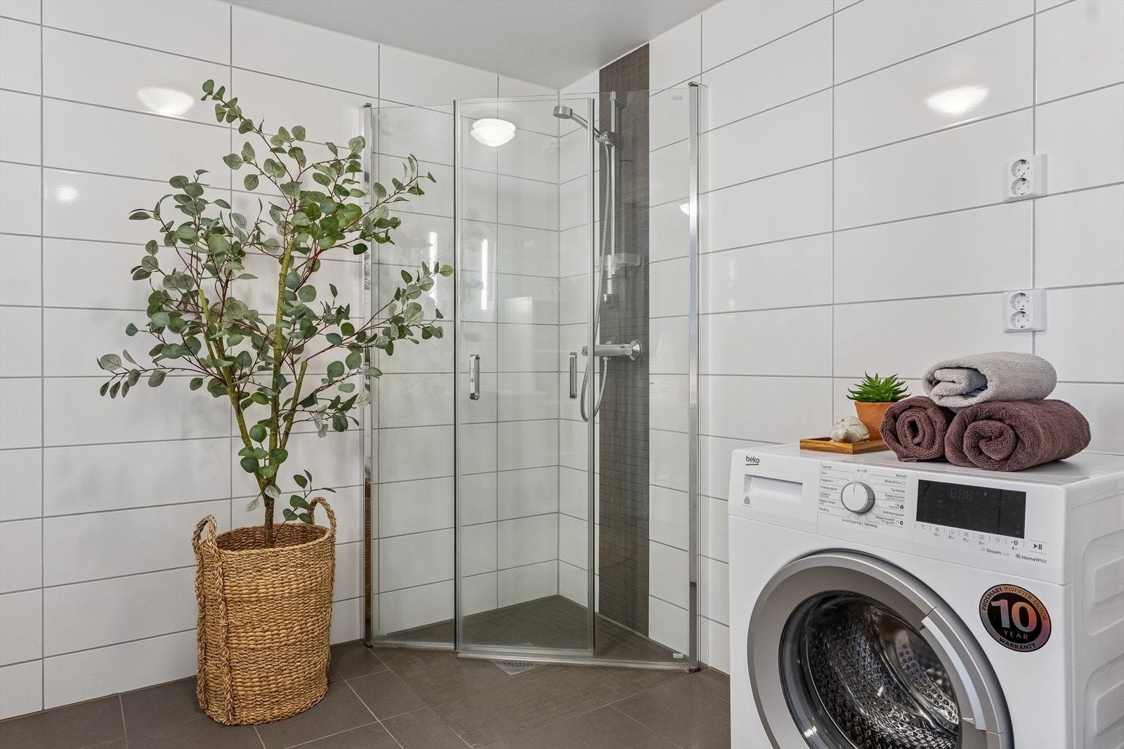 Plassbesparende dusjvegger og opplegg for vaskemaskin. Galleribilde