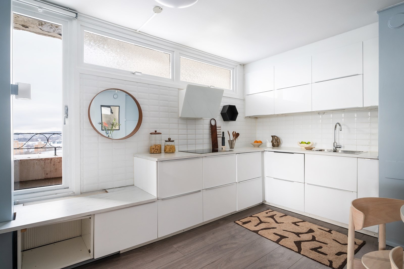 Kjøkkeninnredningen har lyse, glatte fronter, laminat benkeplate og rikelig med både skap- og benkeplass. Galleribilde