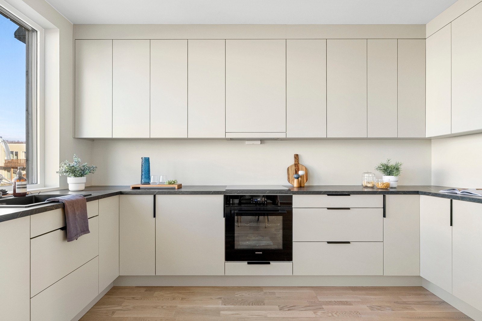 Innredningen fra Bjerks trevarefabrikk har lyse, glatte fronter og mørk benkeplate av laminat med dobbel oppvaskkum. Galleribilde