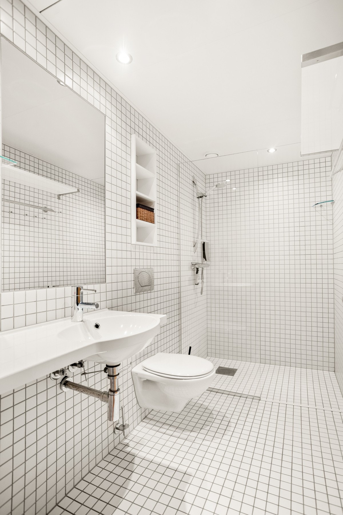 Hovedbadet er innredet med nedfelt servant, veggmontert toalett og badekar med dusjmulighet. Galleribilde