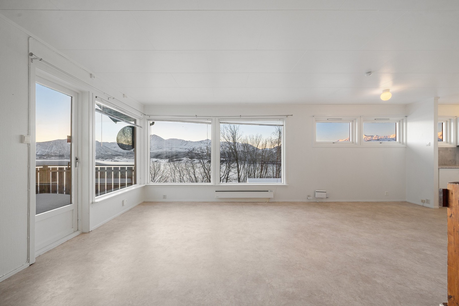 Lys og romslig stue med meget godt innslipp av naturlig lys gjennom store vindusflater Galleribilde