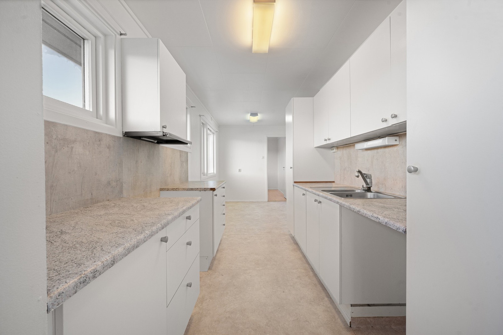 Kjøkkenet har lys innredning med god skap- og benkeplass Galleribilde