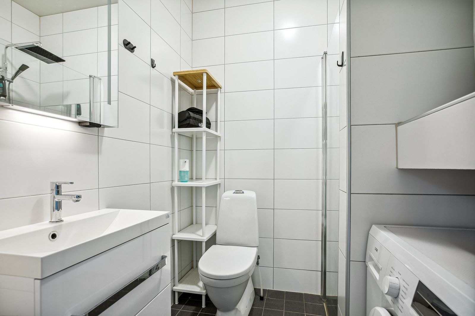 Badet har pene fliser på gulv og vegger, med vegghengt servantinnredning. Galleribilde