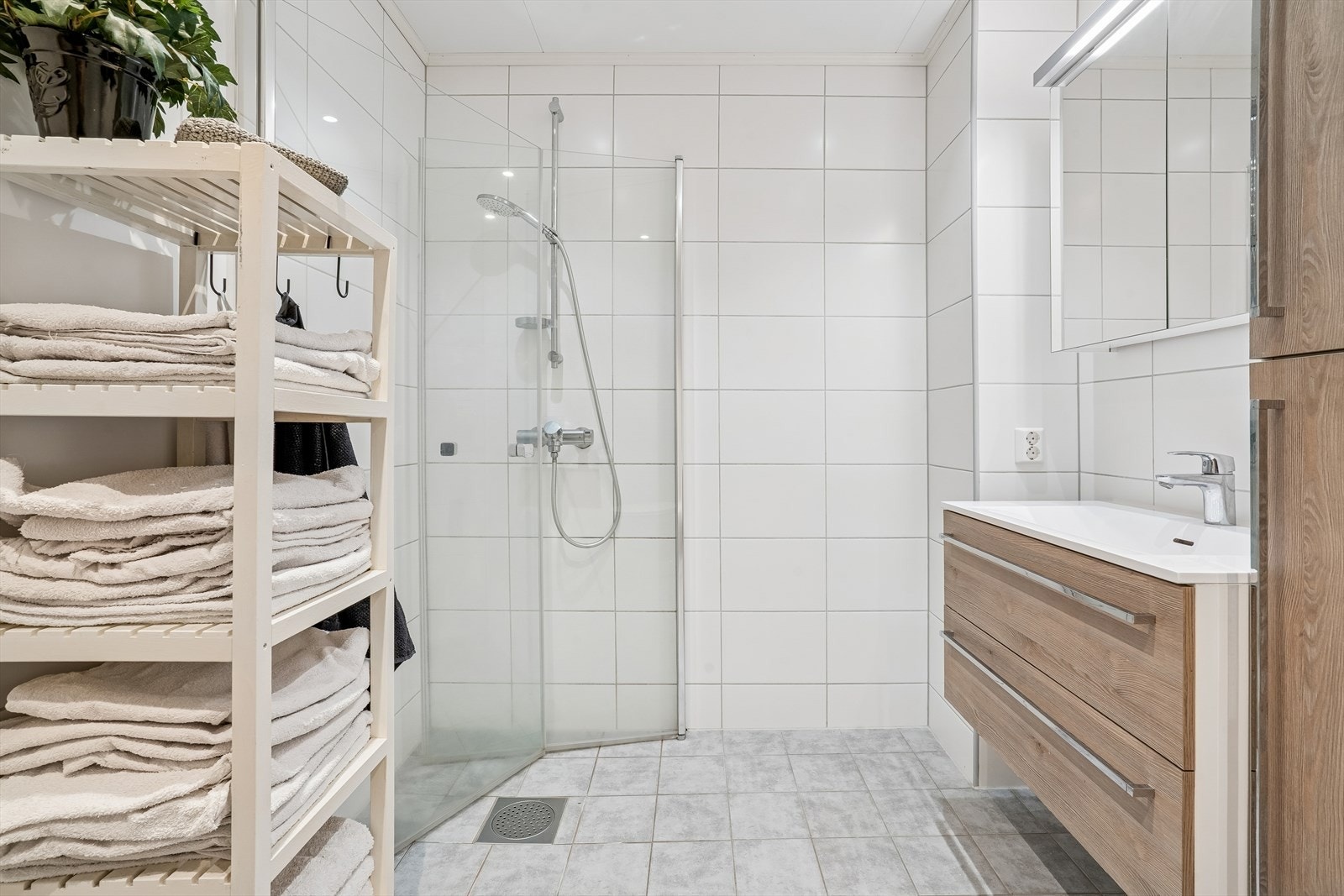 Her er det dusjhjørne med innfellbare glassdører og en moderne servantinnredning. Galleribilde