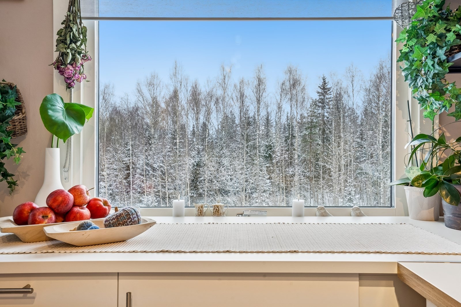 Det store kjøkkenvinduet gir godt med arbeidslys og en fin utsikt mot skogholtet Galleribilde