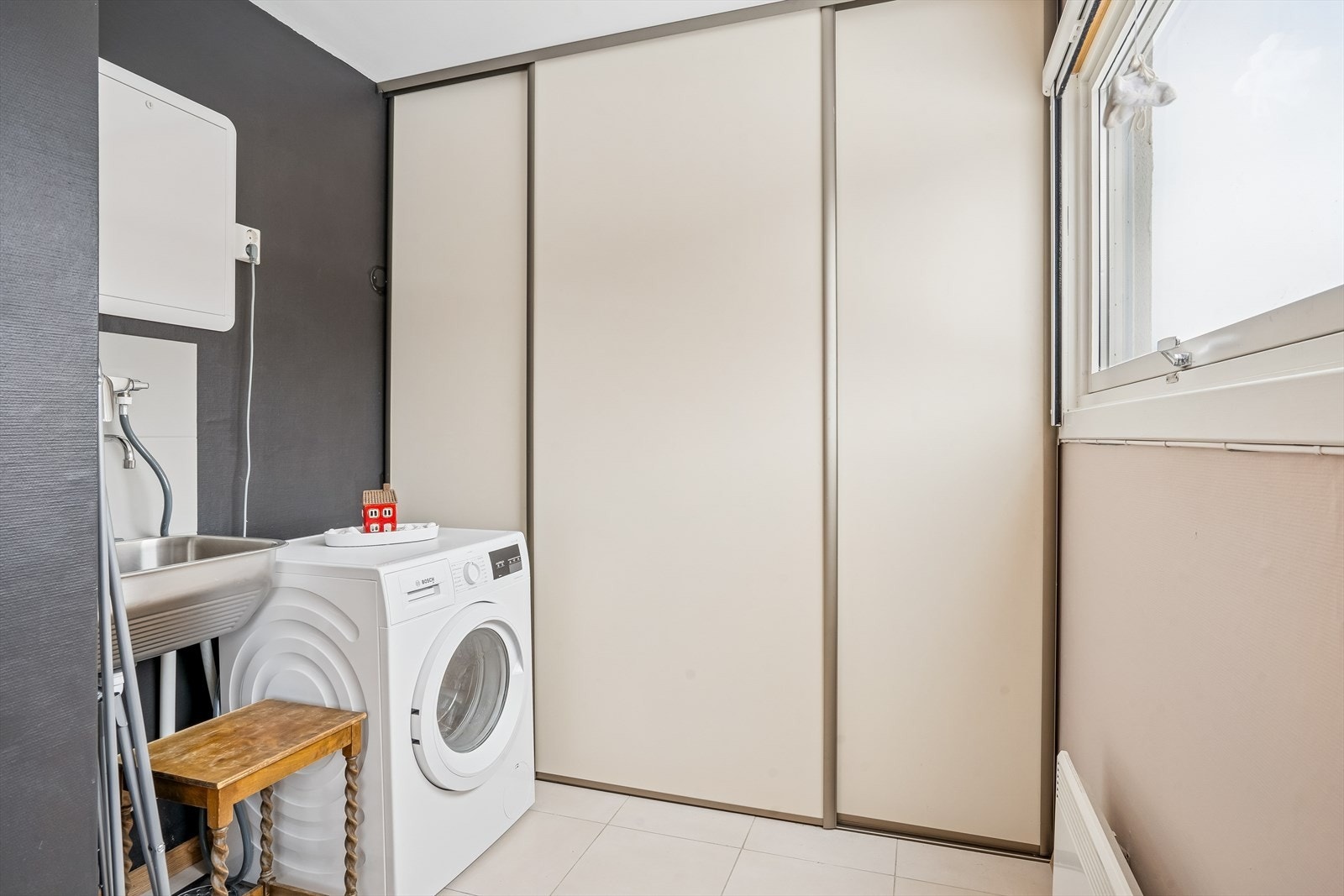 Leiligheten har et eget vaskerom med åpen løsning mot kjøkkenet. Her er det opplegg for vaskemaskin og praktisk utslagsvask. Galleribilde
