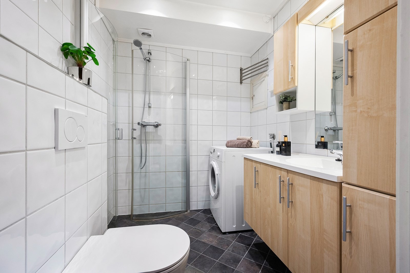 Badet har helfliset gulv og vegger. Badet har også montert opplegg for vaskemaskin. Galleribilde