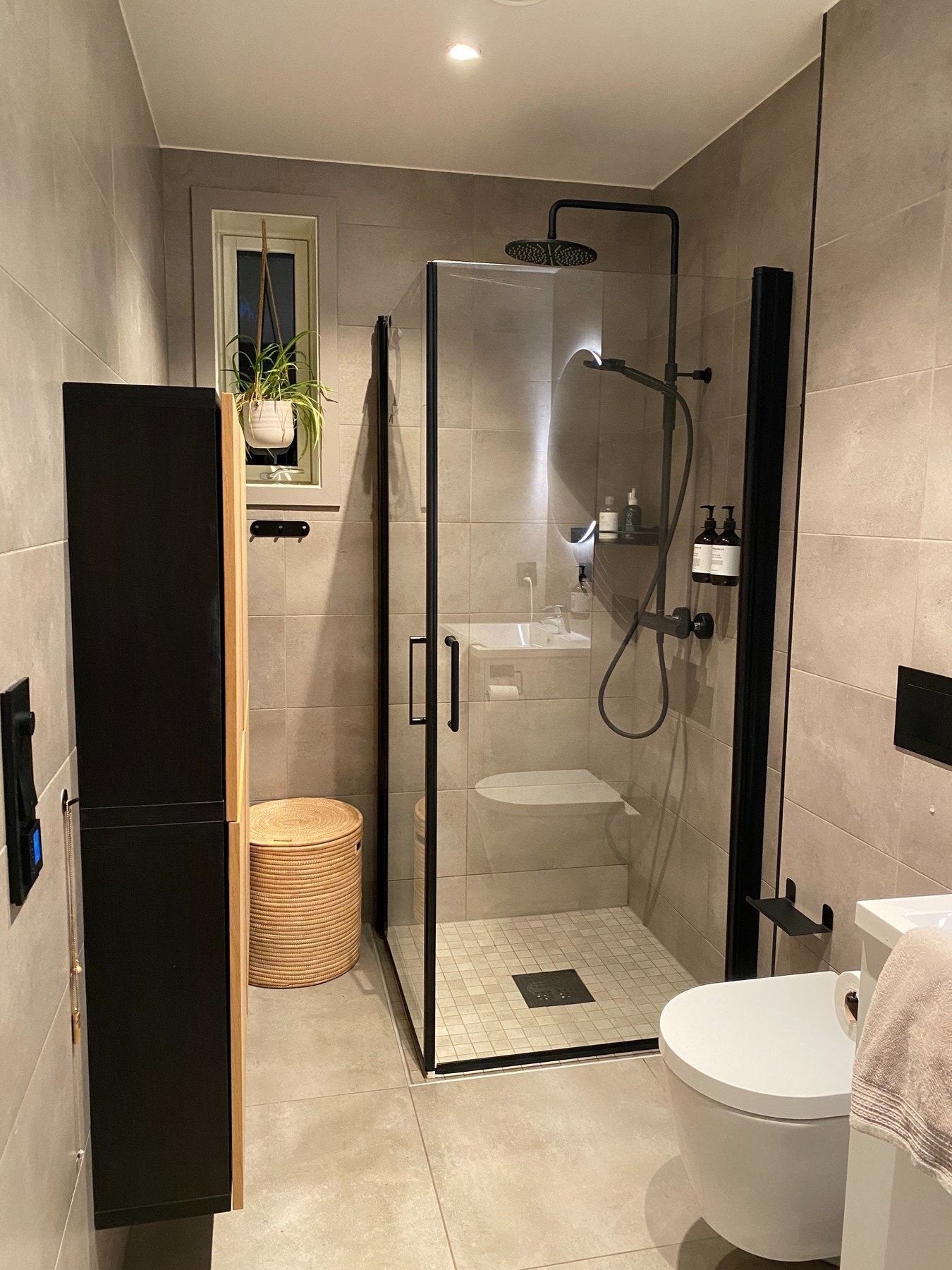 Baderommet i første etasje er delikat og tidsriktig med flis på vegger og gulv. Dusjhjørnet har sorte detaljer, sort blandebatteri og dusjhoder, samt mosaikkflis på gulv Galleribilde