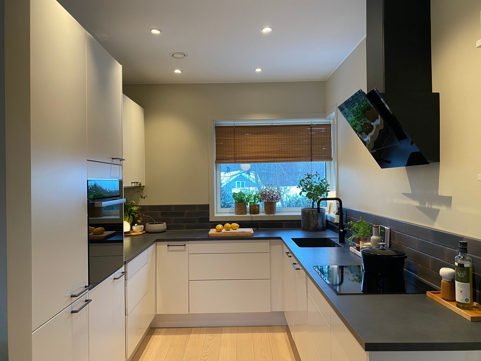 Det er integrert komfyr og koketopp, kjøl/fryseskap og oppvaskmaskin. Det er sort avtrekk som står i stil med benkeplaten og komfyren Galleribilde