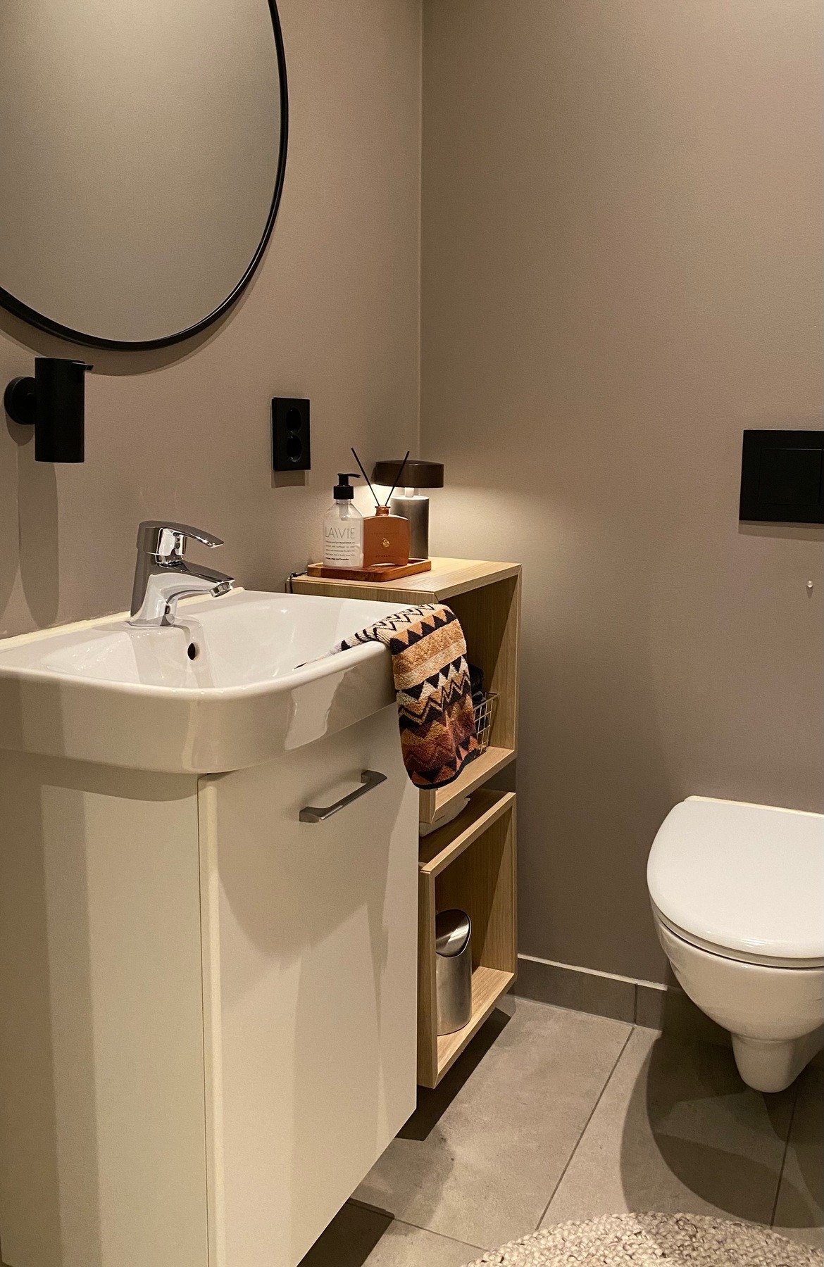 Det er et separat toalettrom med vegghengt klosett og en servant i innredning med underskap og tilknyttede vegghengte hyller Galleribilde