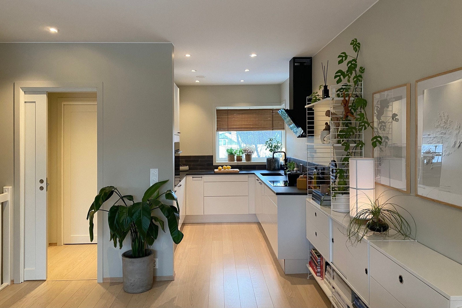 Her har man et delikat kjøkken med hvit innredning av glatte fronter. Den mørke benkeplaten lager en stilig kontrast. Downlights i himlingen sørger for god belysning Galleribilde