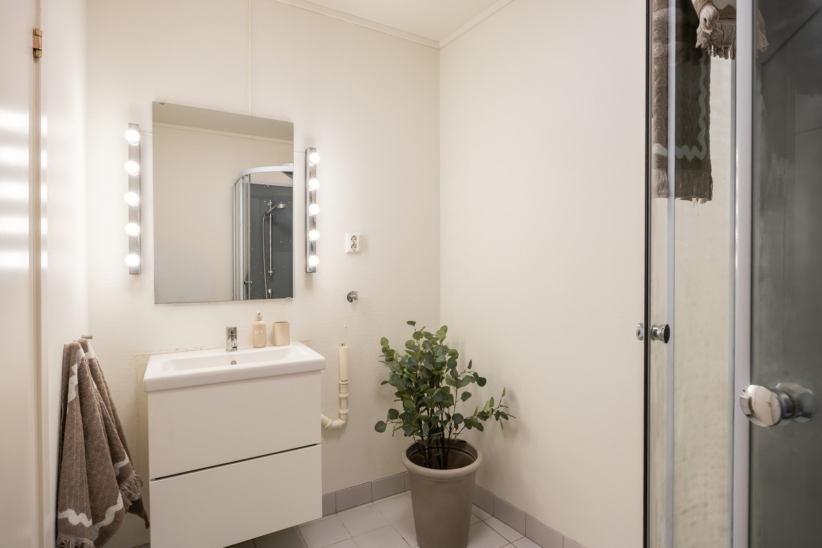 Praktisk utforming med flislagte gulv, innredning med plass til vaskemaskin. Galleribilde