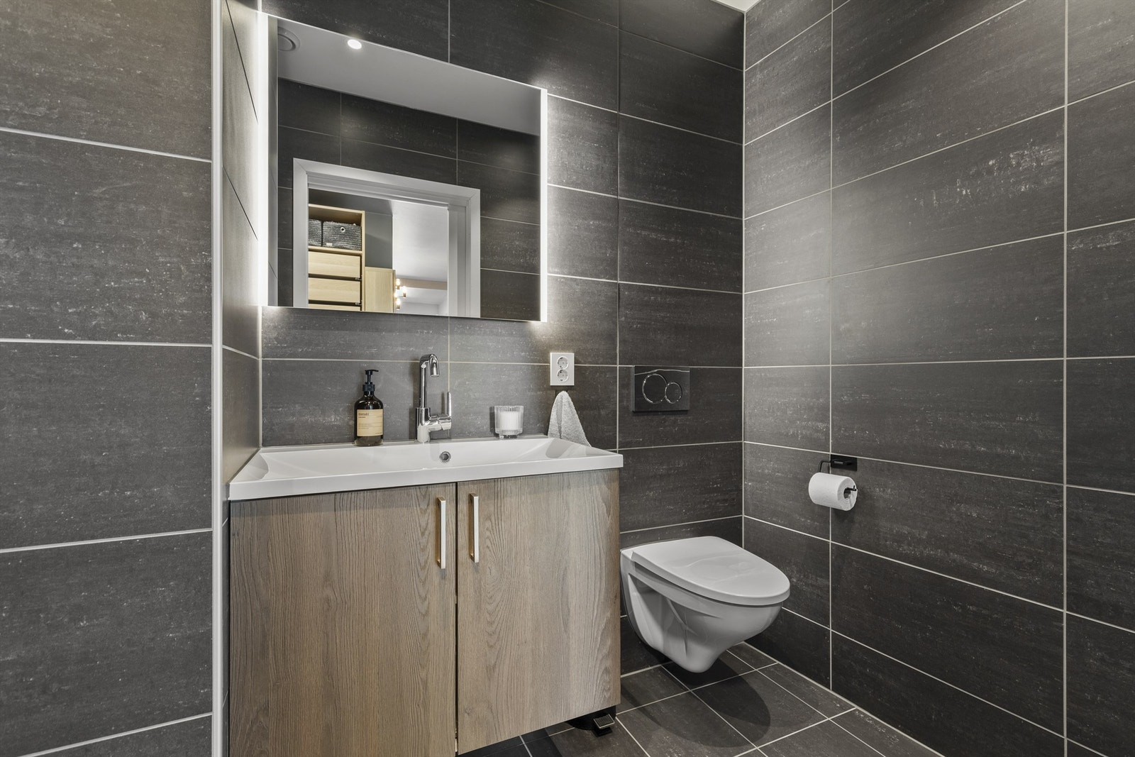 Flislagt gulv med varme og flislagte vegger. Vegghengt toalett. Galleribilde