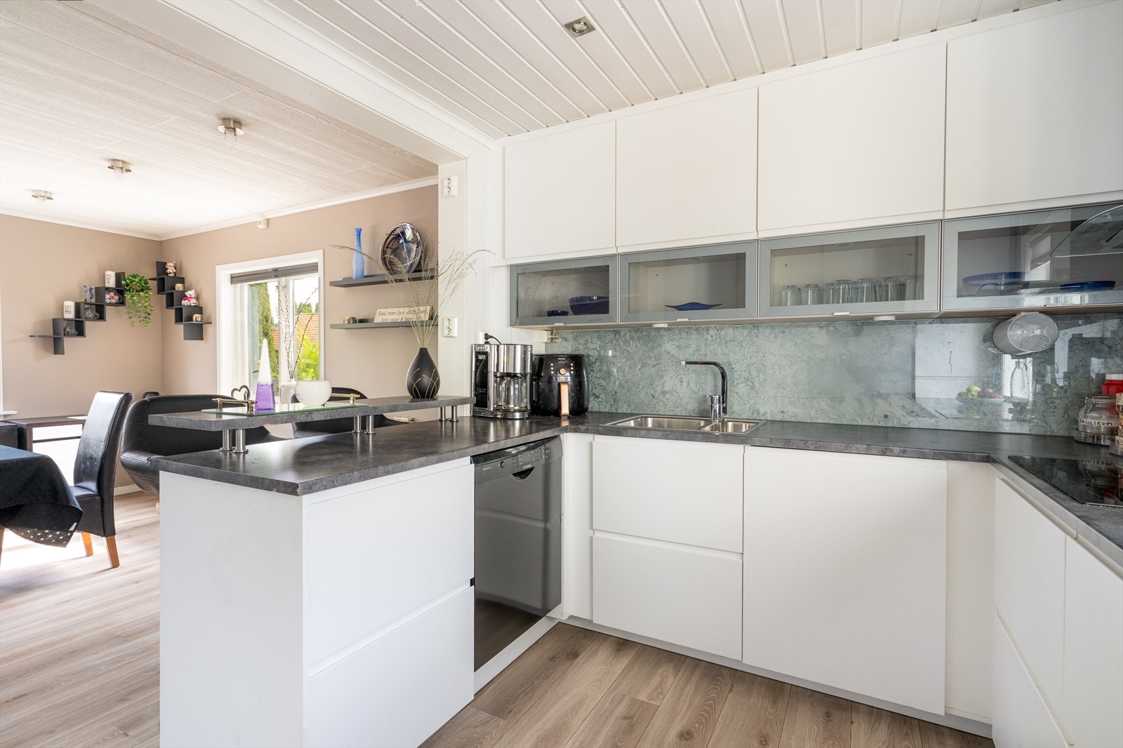 Kjøkkenet har pen IKEA innredning med glatte fronter og laminert benkeplate. Det er praktisk øy ut mot stuen med to frokostplasser. Galleribilde