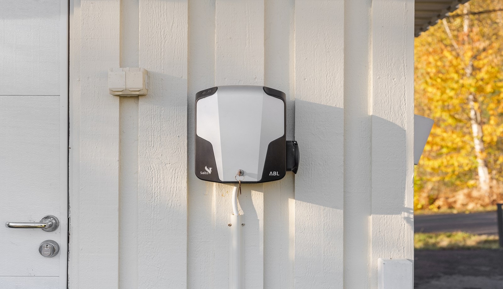 Garasjen har innlagt strøm, automatisk portåpner og ladeboks for elbil montert på ytterveggen. Galleribilde